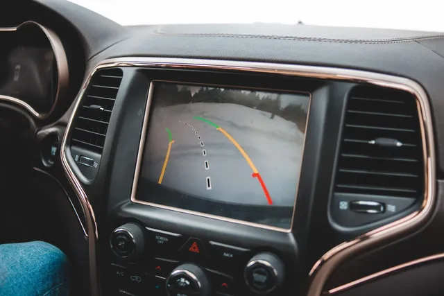 A backup camera view with guidance lines on a dashboard display