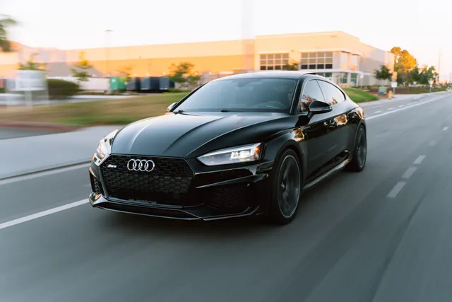 A black Audi coupe on an open road