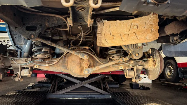 A rear axle and differential seen from below on a workshop lift