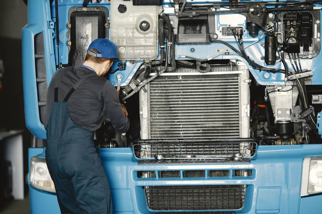 A tilted truck cab exposing the radiator during heavy duty service