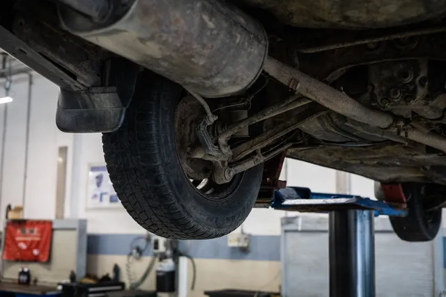 An exhaust pipe running beneath a vehicle raised on a lift
