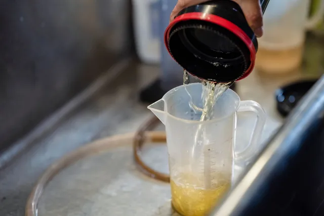 Fresh fluid being poured from a bottle into a measuring jug