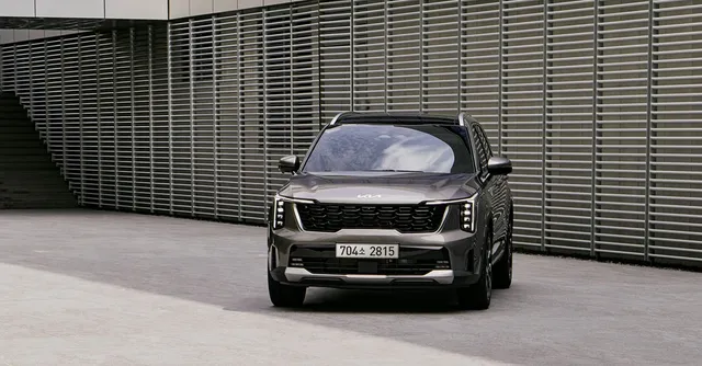 A gray Kia SUV alongside a wall