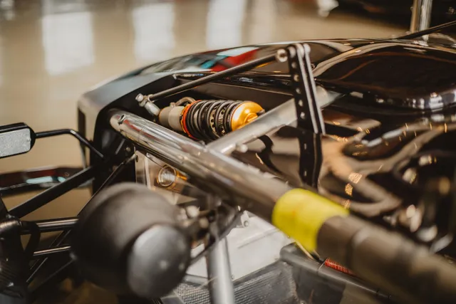 An exposed suspension linkage and coilover damper